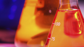 实验室烧瓶和橙色液体的图像。